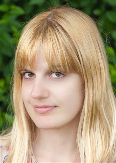 Julianne Pachico looks at the camera in front of a background of trees