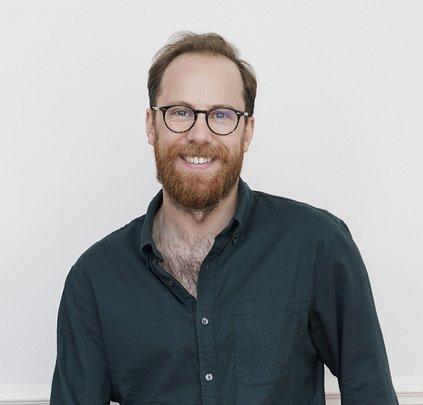 Headshot of author Eli Burnstein, a man with a beard and glasses