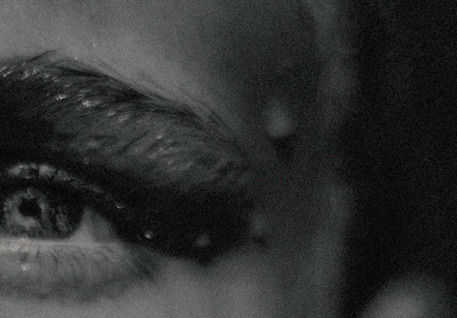 A close up, black and white image of a woman's eye 