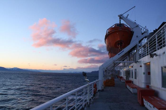 A view of the sunset over the water from the deck of a ferry in Alaska