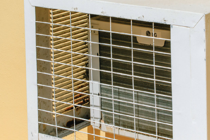 detail of an air-conditioned on a yellow wall.