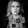 A portrait of author Elaine Feeney against a black background