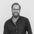 Headshot of author Eli Burnstein, a man with a beard and glasses